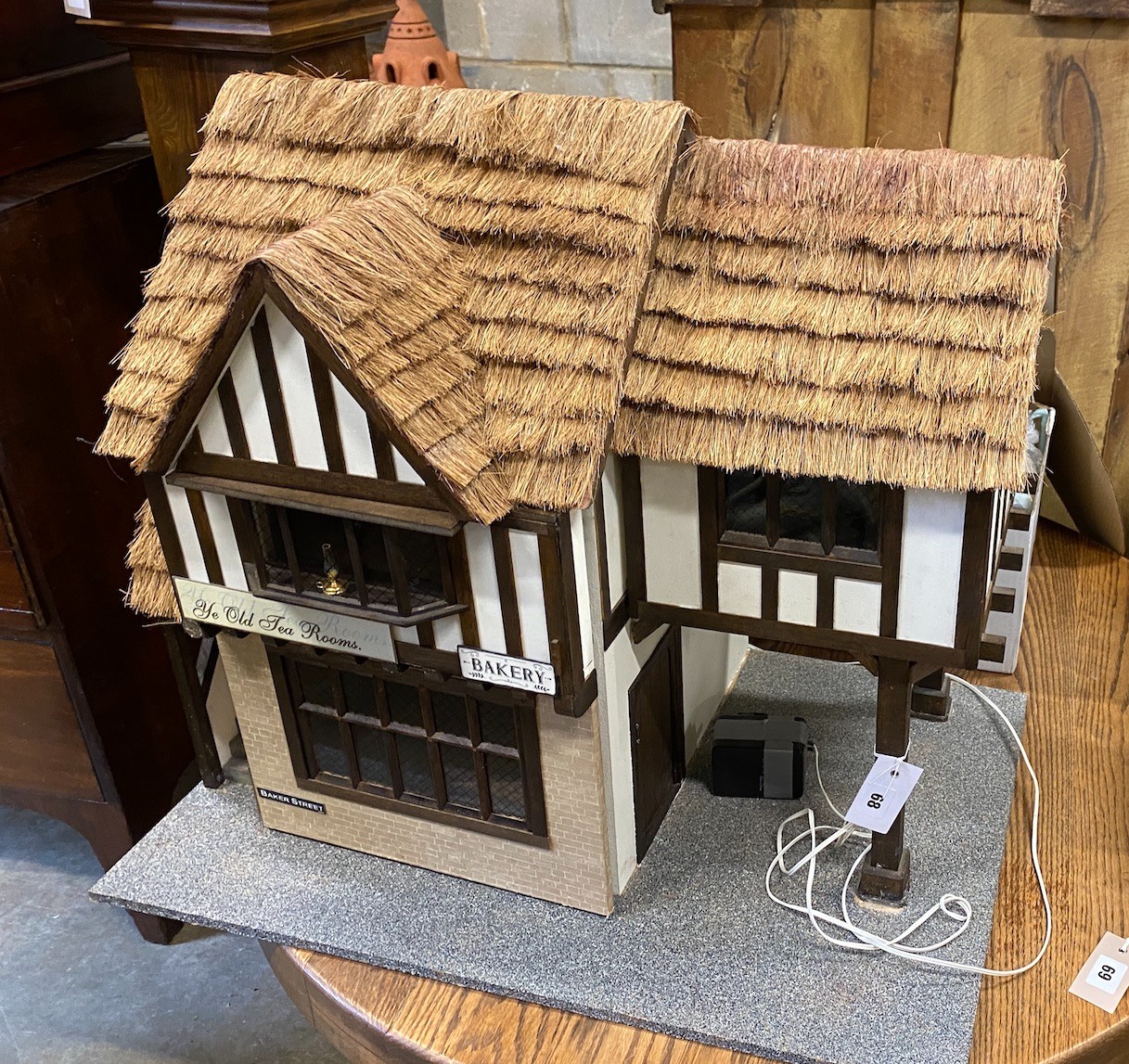 A contemporary doll's house modelled as a thatched house with accompanying furniture, width 70cm, height 60cm